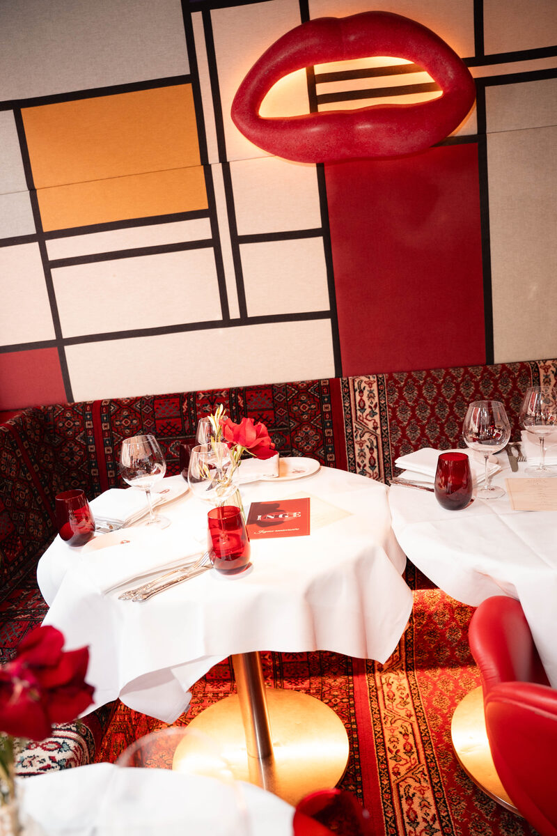 Rose-dressed dinner table with a custom red-lacquer birthday menu card, at Bisous in Amsterdam